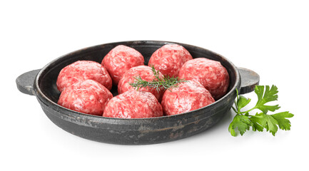 Baking dish with raw meat balls, parsley and dill on white background