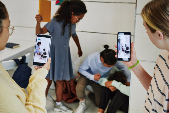 School bullying scene with children recording fight on smartphone camera and posting it to social media