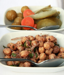 Turkish appetizer food 'Chickpeas cold cuts' and pickles on the dinner plate.