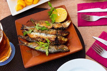 Fried sardines served with slice of lemon, seafood appetizer