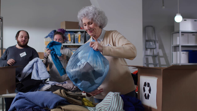 Diverse volunteers sort donated clothes for recycling in eco-friendly community - Powered by Adobe