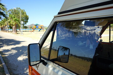 Transporter der Achtzigerjahre als Wohnmobil für Camping und Vanlife unter Palmen im Sonnenschein...
