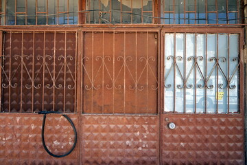 Rostiges altes Tor mit Schmiedeeisen undEingangstür eines Wohnhaus in Ayvalik am Ägäischen Meer...