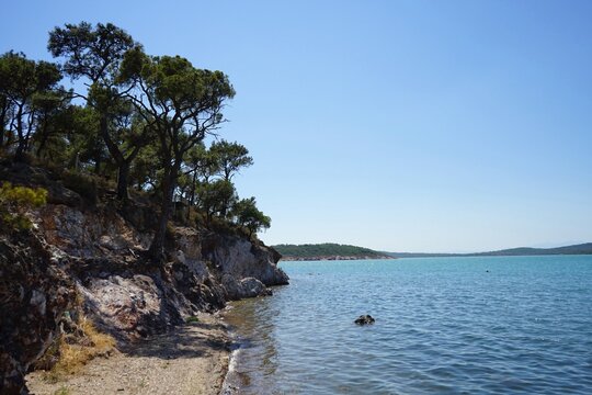 Felsk&uuml;ste mit Strand im Sommer bei blauem Himmel und Sonnenschein in der Bucht vor Ayvalik in der Provinz Balikesir am &Auml;g&auml;ischen Meer in der T&uuml;rkei