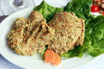 Carrot-walnut-bulgur wheat appetizer with vegetables on dinner plate.