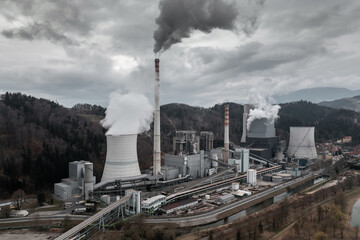 Smoking chimney stack and cooling tower of a coal power plant, aerial view