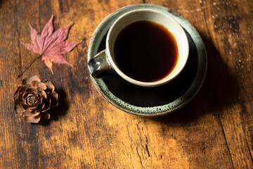 コーヒーカップとテーブルの上の紅葉したもみじ