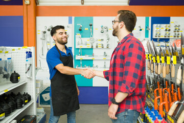 Hardware store employee with a happy man customer - obrazy, fototapety, plakaty