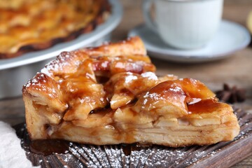 Slice of traditional apple pie on wooden board, closeup
