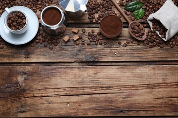 Flat lay composition with roasted coffee beans on wooden table. Space for text