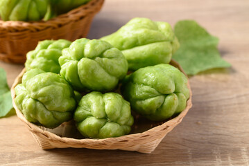 Chayote squash fruit in basket on wooden table, Organic vegetables