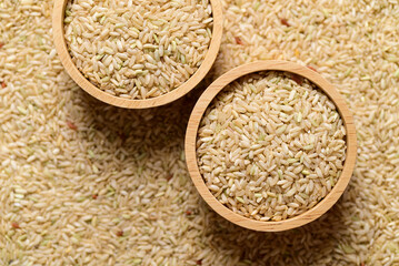 Thai brown rice seeds in wooden bowl, Organic rice, top view