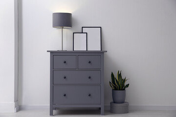 Grey chest of drawers in stylish room interior