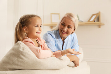 Fototapeta premium Happy grandmother spending time with her granddaughter at home