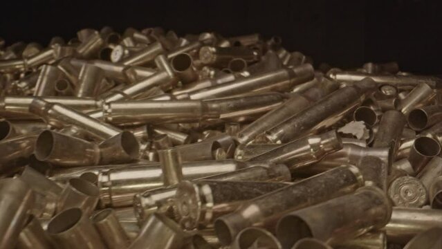 Macro dolly of out of a large pile of spent bullet casings