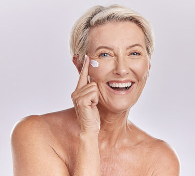 Skincare, beauty and wellness cream of happy senior woman with smile for skin care on her face in a studio background. Portrait of a mature model lady in beauty, wellness and health and cosmetics.