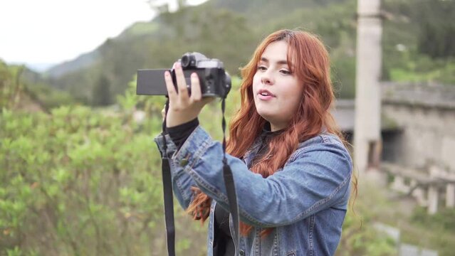 Joven chica grabando un video blog en medio del campo