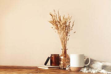 Autumn cozy composition. A cup of coffee, a plaid, a candle, dried flowers on a light background. Autumn, fall concept.