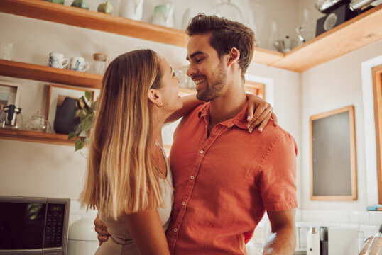 Romance, happy and love couple hugging, smile and bonding in kitchen. Romantic boyfriend and girlfriend embracing, enjoying their relationship and being carefree together.