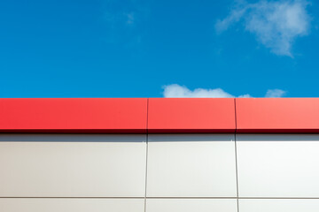 The exterior wall of a contemporary commercial style building with aluminum metal composite panels and glass windows. The futuristic building has engineered diagonal cladding steel frame panels.