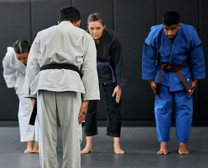 Fitness, strength and respect between karate trainer leading a class, bow and greeting martial arts student at a dojo or studio. Diverse group training and learning self defense and endurance skills © Delcio Fernandes/peopleimages.com