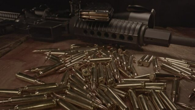 beautiful dolly out of loaded magazine on AR-15 assault rifle and revealing a pile of .223 ammunition