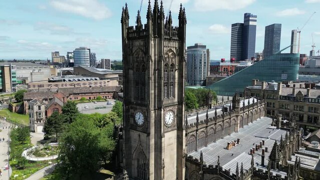 Aerial drone flight around Manchester Cathedral showing off the surrounding gardens and an array of skyscrapers and rooftops in the Background