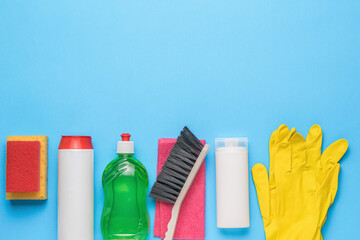 Detergents, gloves, brush and rags on a blue background. Cleaning kit.