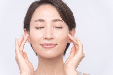 スキンケアをしているミドル世代の日本人女性。