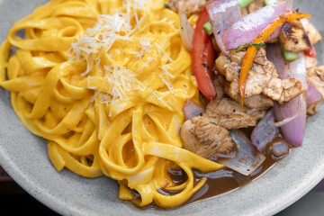 plate of noodles a la huancaina with saltado chicken
