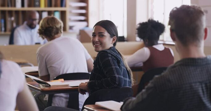 High school student in a classroom learning, education and studying at her desk in a happy portrait. Test, exam and knowledge of teenager girl with smile, class of youth and teacher in the background - Powered by Adobe