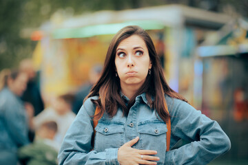 Woman Feeling Hungry Looking for Something to Eat in Amusement Park. Person accusing stomachaches after eating street food at funfair festival
 - obrazy, fototapety, plakaty