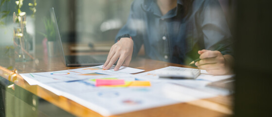 businesswoman working on desk office with using a calculator to calculate the numbers, finance accounting concept