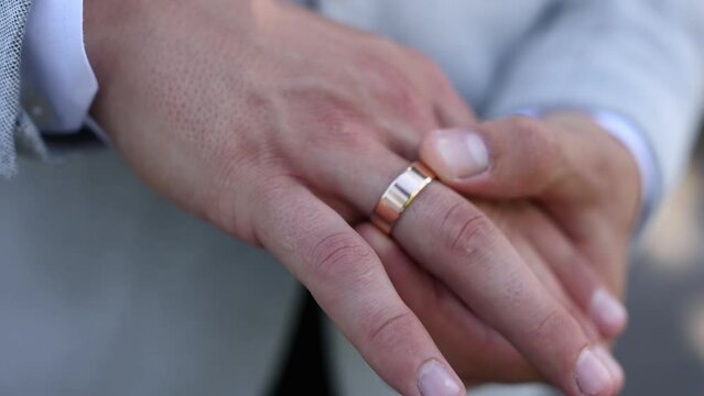 gold wedding ring on the finger of the groom's man