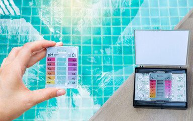 Water test kit in girl hand with Tablet water testing test kit on swimming pool edge, Chlorine and...