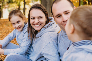 Fototapeta premium Family group of four relaxing outdoors In autumn park. Active lifestyle. Autumn forest. Happy family, childhood.
