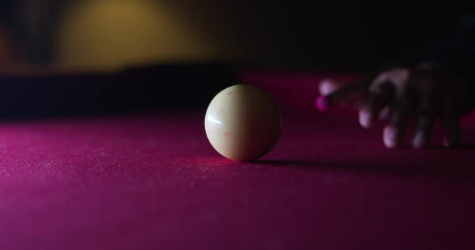 Man ready himself and hits the cue ball on the pool table.