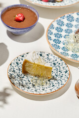 Classic cheesecake new york with caramel on ceramic plate on light background. Cheesecake in summer menu with shadows. Desserts menu - caramel cheesecake. Aesthetic composition with slice of cake.