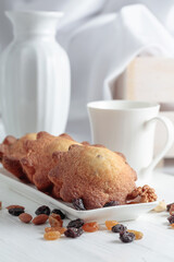Cupcakes with nuts and raisins on a kitchen table.