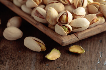 Salted pistachios on an old wooden table.