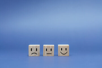Emotion face on wooden cube.  Ranking for service customer review and feedback concept