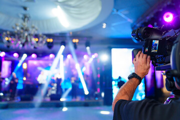 videographer with broadcast video camera to show on large screens. 
