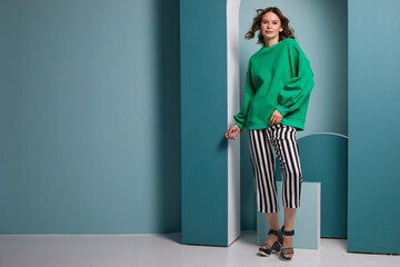 Fashion asian female model in green trendy sweater and pants.
