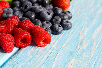 Berries on a wooden background. Summer or spring Organic berry. Strawberries, Raspberries, Blueberries. Agriculture, Gardening, Harvesting Concept.