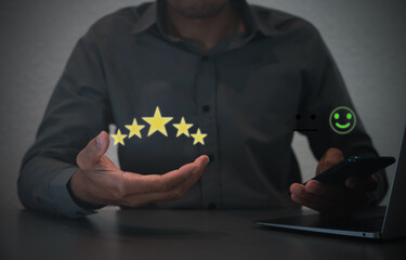 Hand of customer or client holding the stars to complete five stars. with copy space. giving a five star rating. Service rating, satisfaction concept.