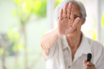 Old elderly woman making stop gesture with palm,campaign against family domestic violence,asian...