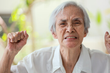 Angry mad senior woman raising fists,facial expression,enraged old elderly grimacing,unpredictable...