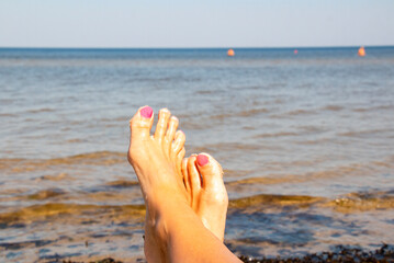 Women's legs, relaxation in the sea wave. Summer vacation concept