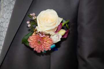 flower boutonniere in the groom suit during the wedding
