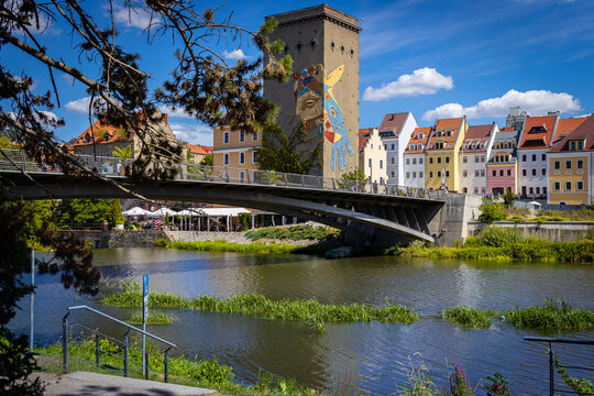Pedestrian bridge over the Neisse River at the Polish-German border in Zgorzelec with historic buildings in the background